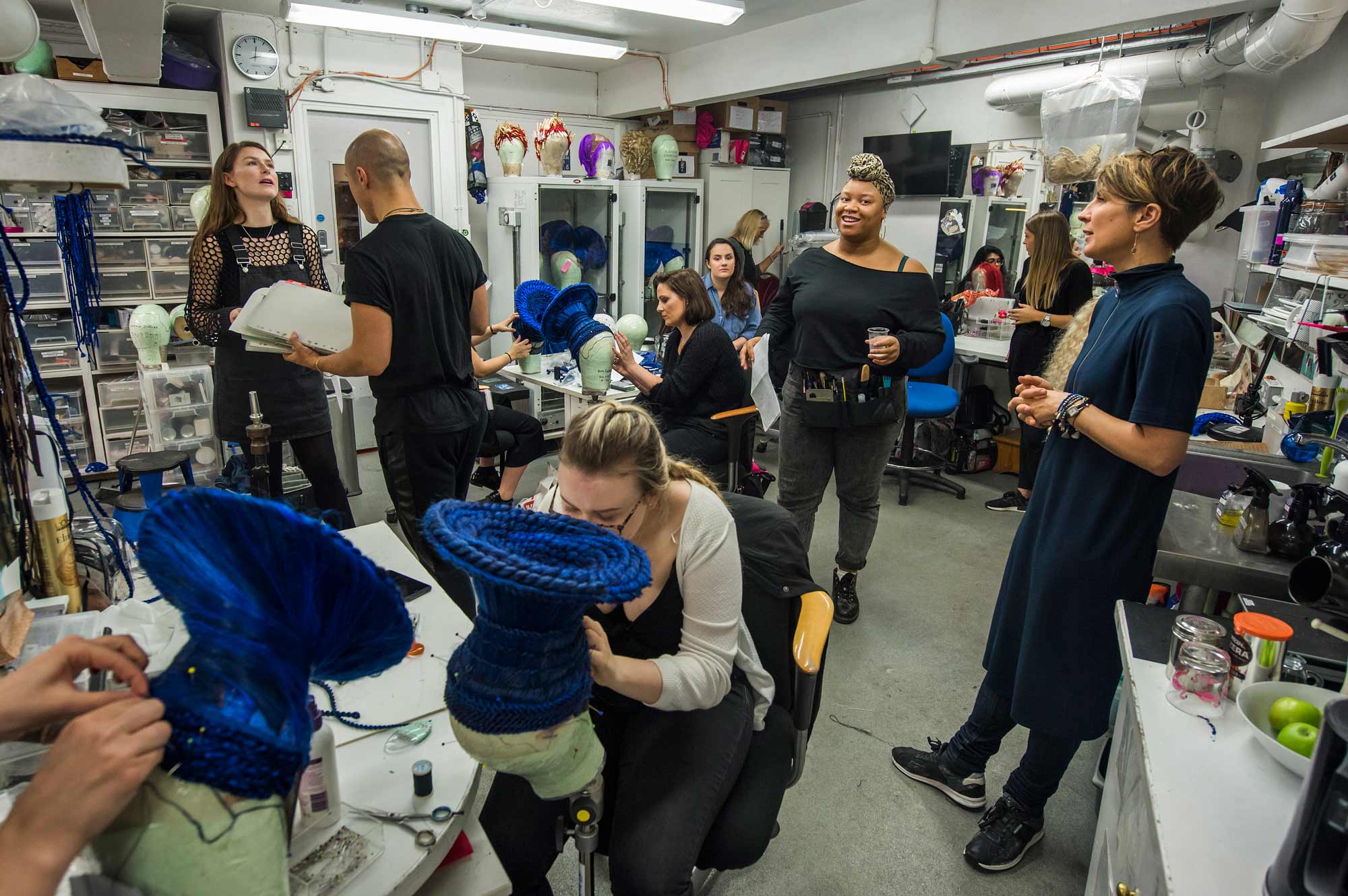 ENO Wigs team adjusting backstage.