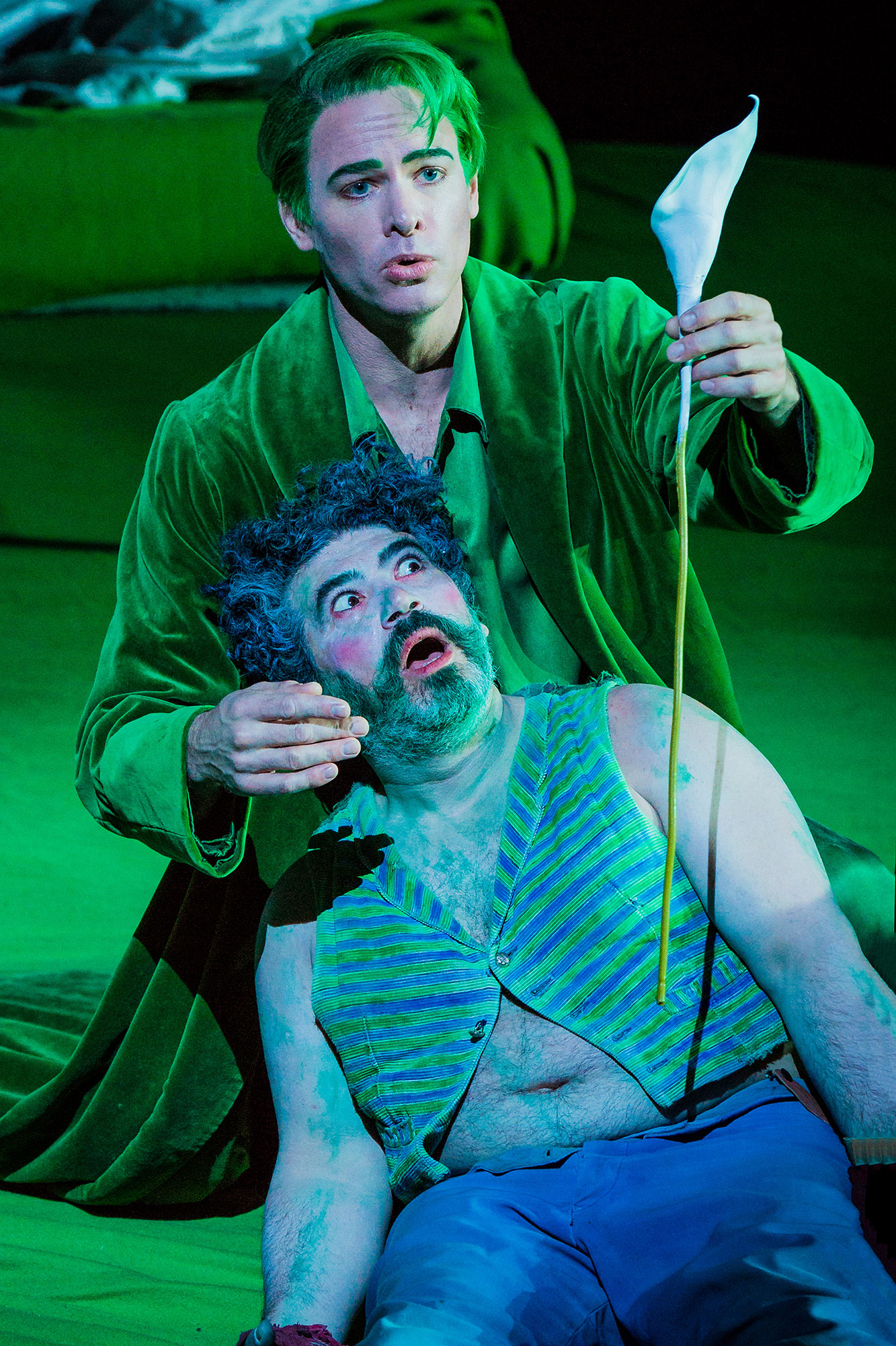 Scen with one man lying on the ground and the other with a flower