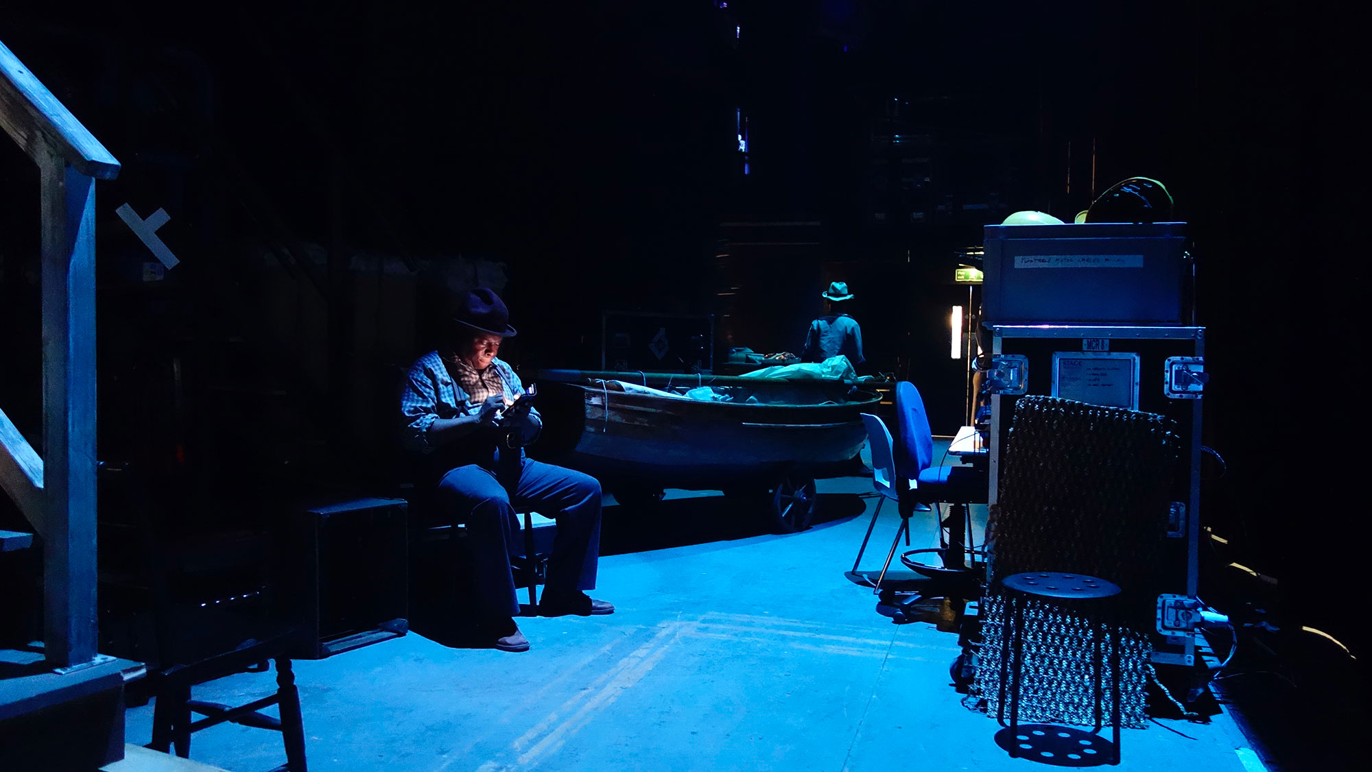 ENO Porgy and Bess: Ensemble member Calvin Lee checks his phone in the wings