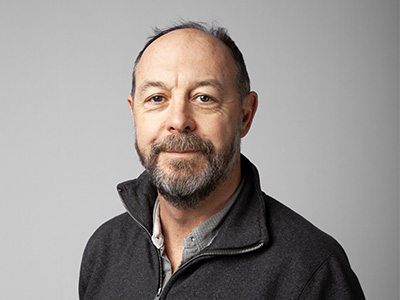 Headshot of David Porter-Thomas smiling at camera