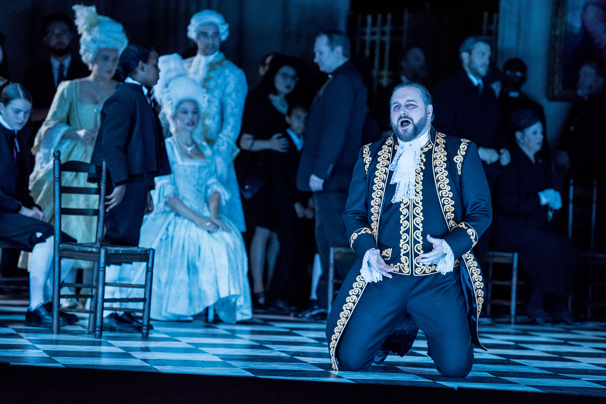 ENO2223 Tosca: Noel Bouley as Scarpia with the Ensemble © Genevieve Girling