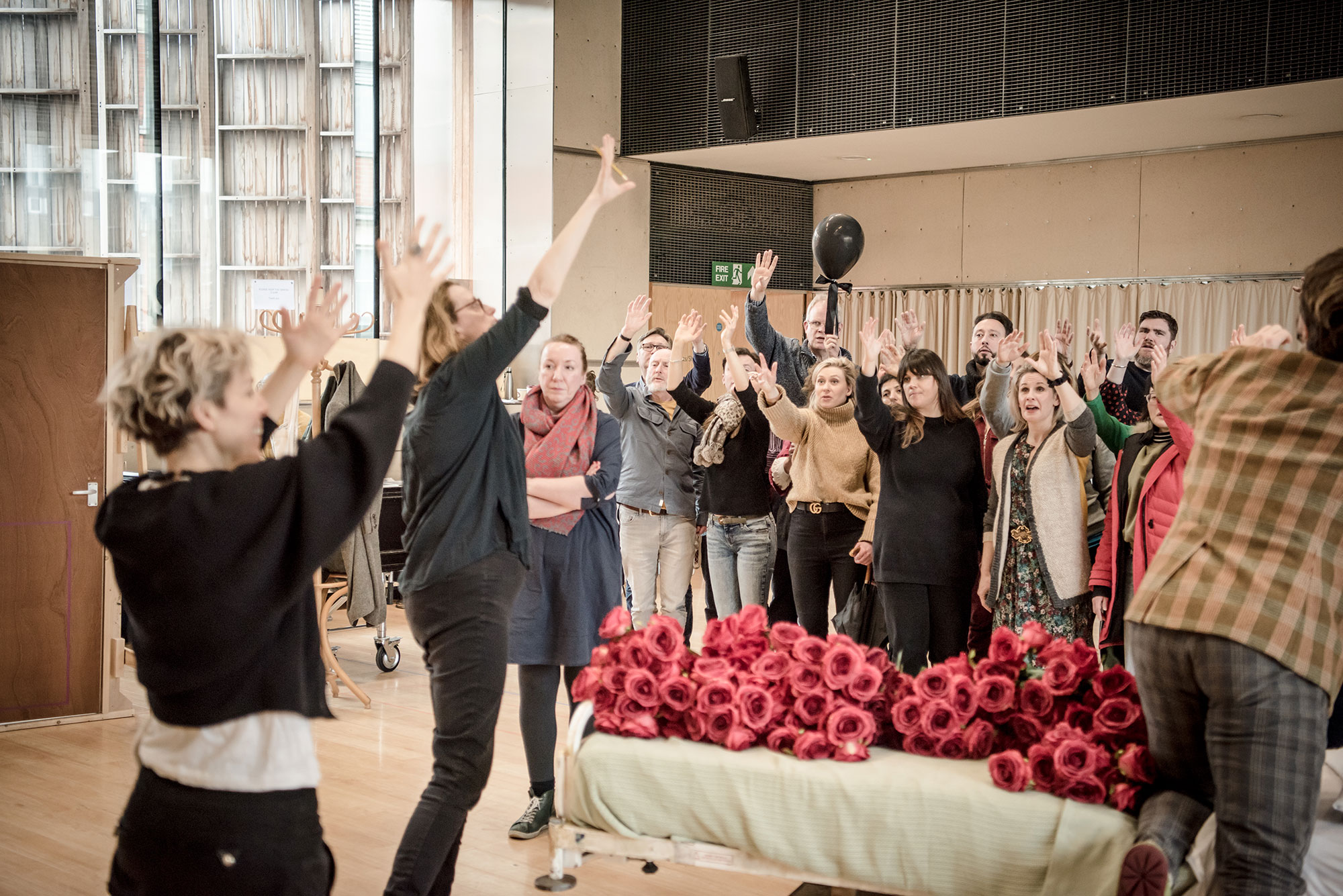 Rehearsal scene with the roses on a bed with cast standing round it
