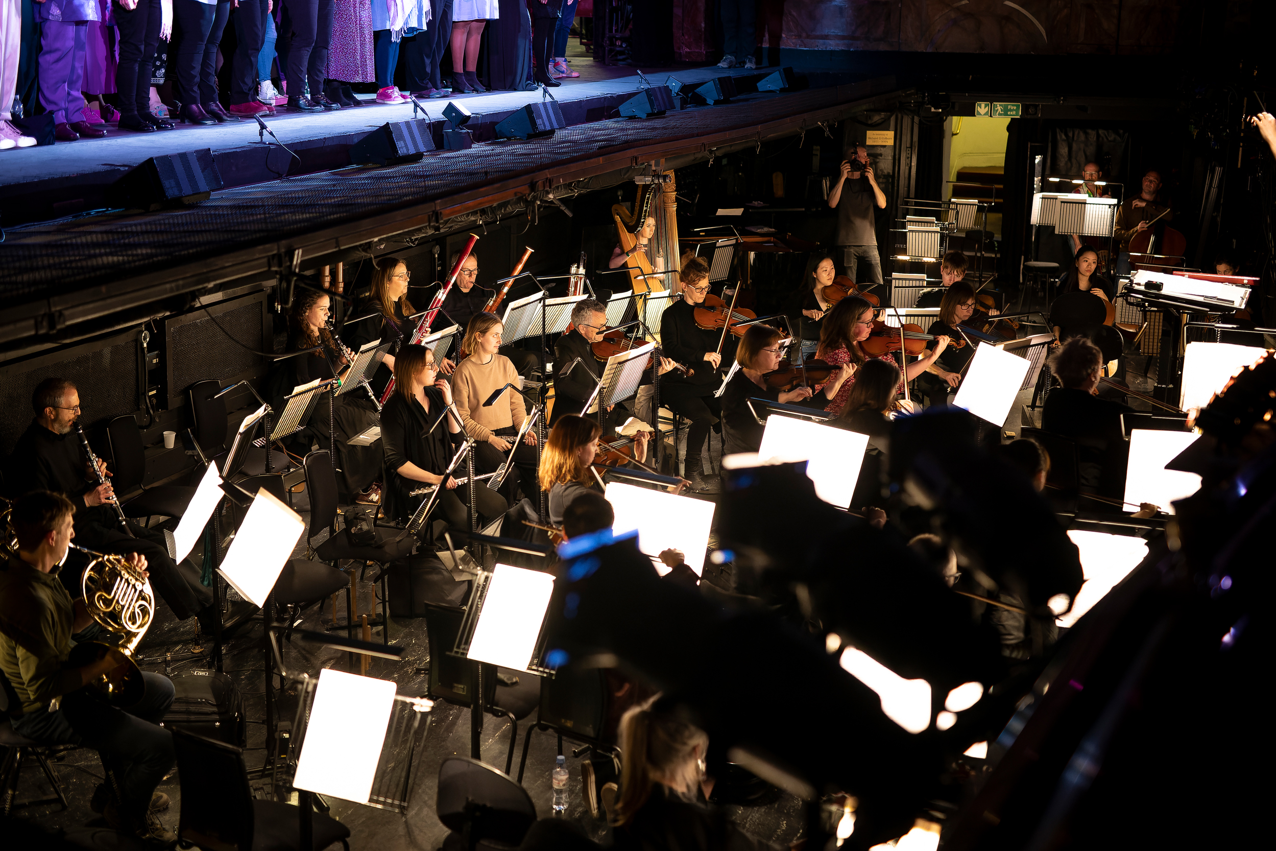 The ENO Orchestra playing with ENO Breathe participants peforming on stage