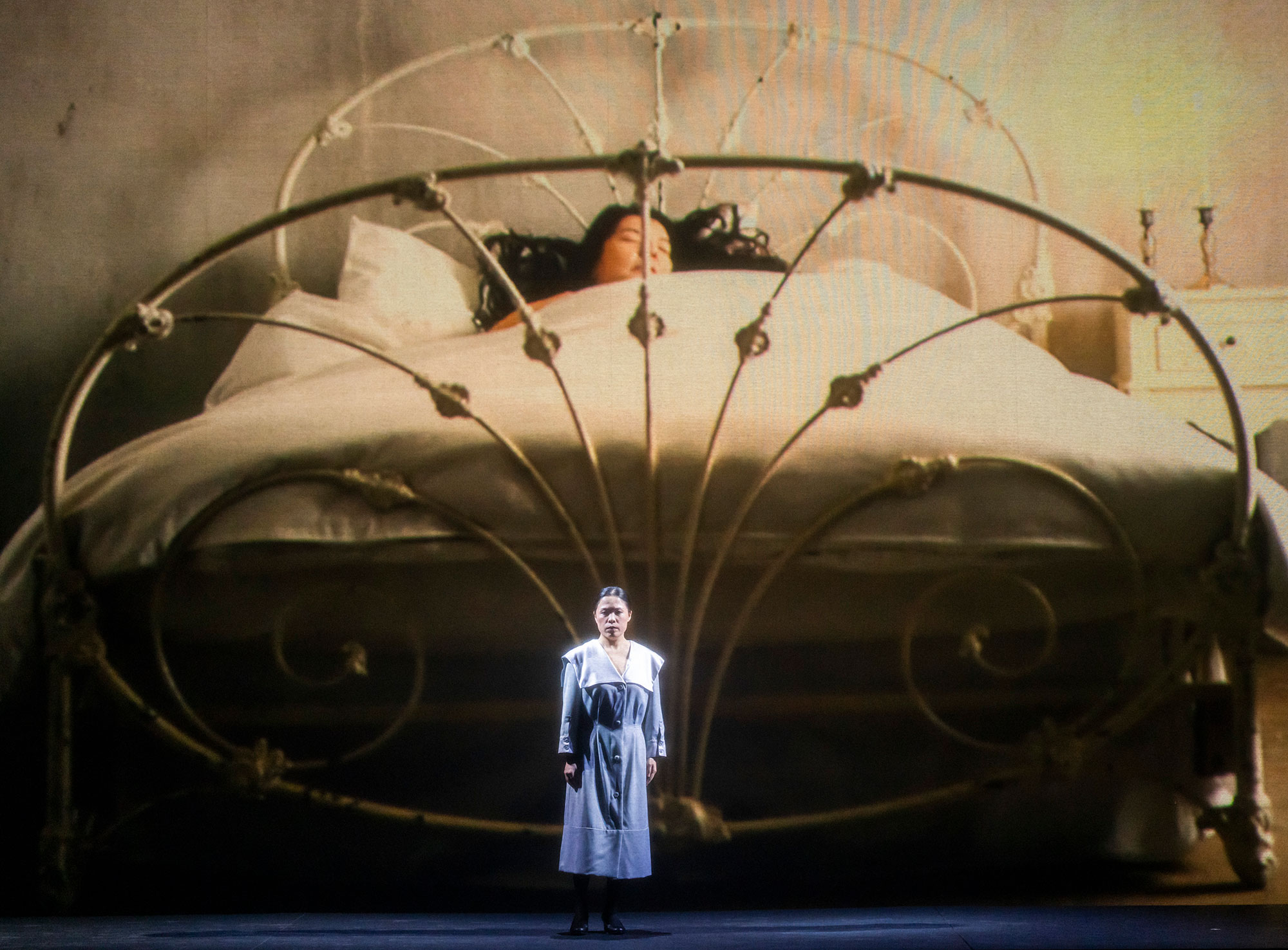 Scene from Maria Callas with a woman in bed and a woman singing